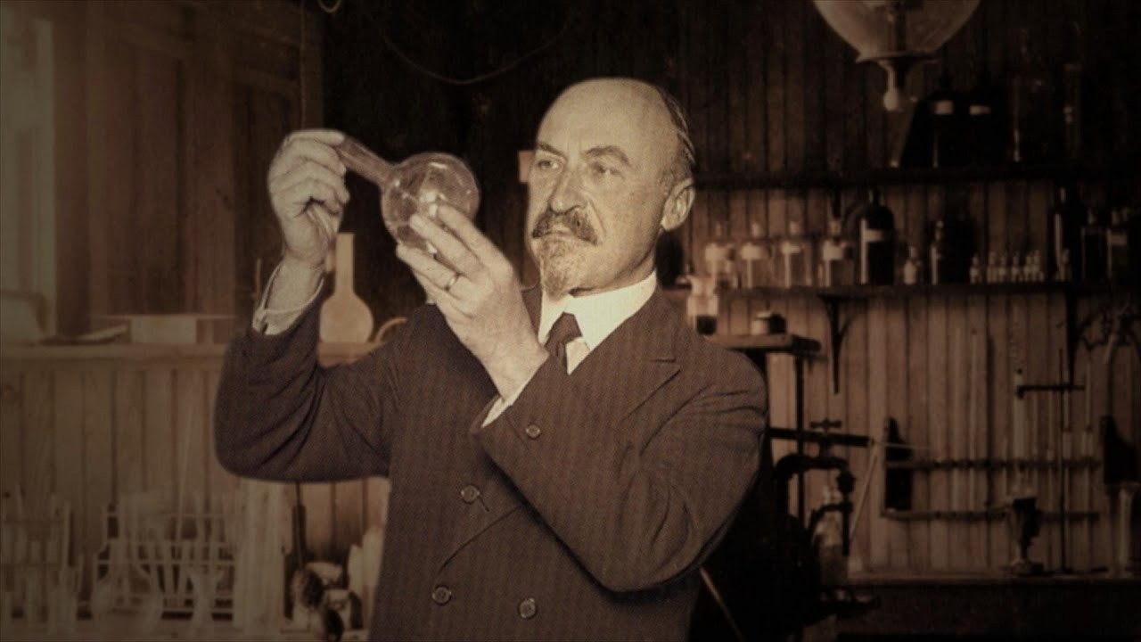 Leo Baekelite holds up a beaker to examine its contents.